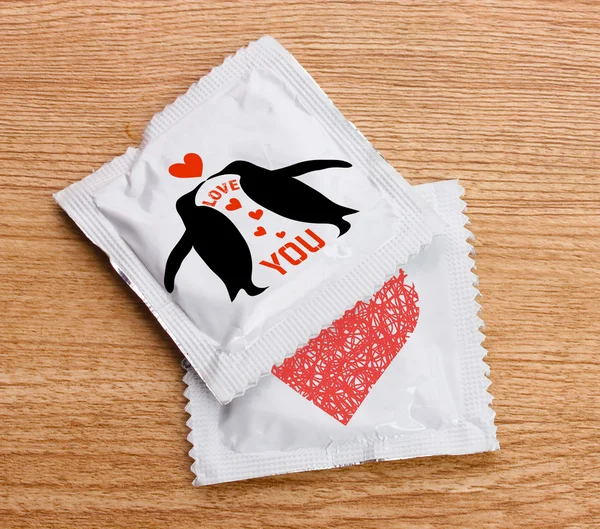 Condoms with pictures on table — Stock Photo, Image