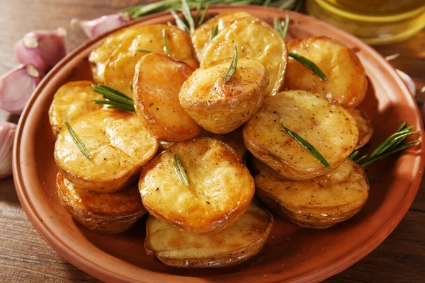 Lahodné pečené brambory s rozmarýnem v misce na stole zblízka — Stock fotografie