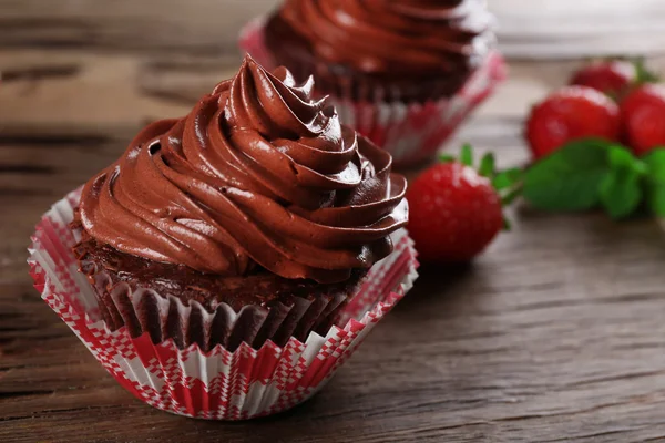 Cupcakes au chocolat et fraises sur fond en bois — Photo