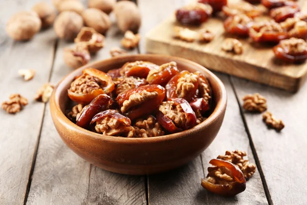 Frutta di noce e dattero in ciotola sul tavolo di legno, primo piano — Foto Stock