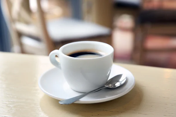 Taza de sabroso café con cuchara en la cafetería — Foto de Stock