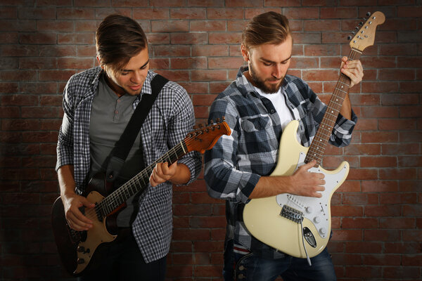 Young men playing guitars