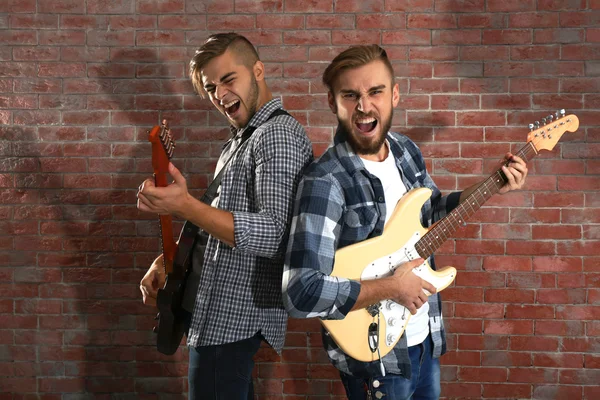 Hombres jóvenes tocando guitarras —  Fotos de Stock