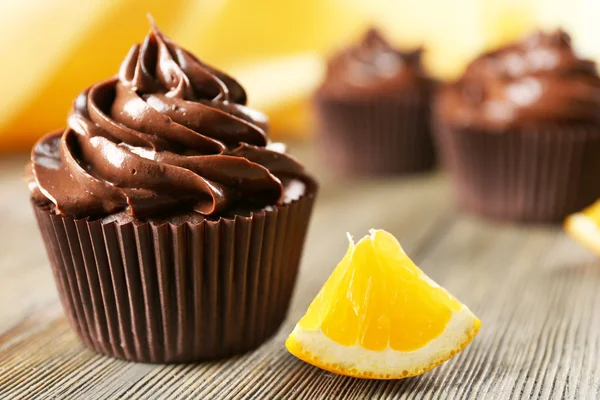 Chocolate cupcakes served with orange on a table — Stock Photo, Image