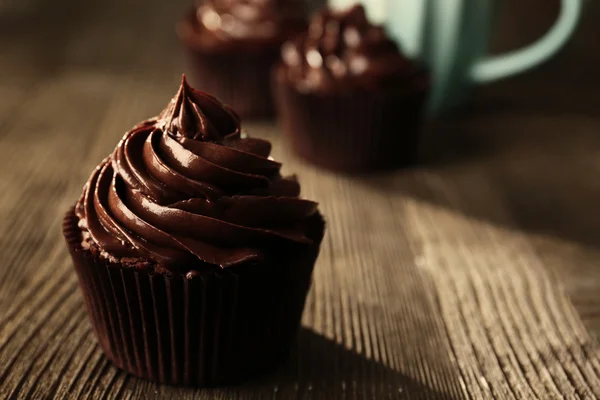 Pastelitos de chocolate servidos con una bebida en la mesa de madera — Foto de Stock