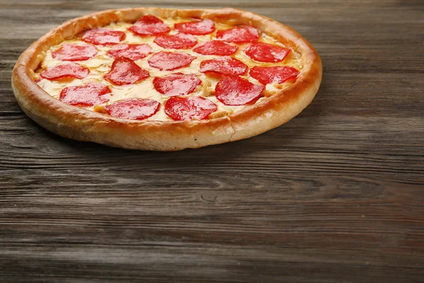 Leckere Pizza mit Salami auf Holzboden — Stockfoto