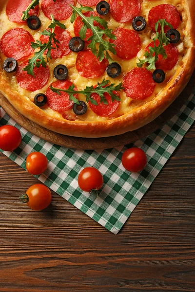 Gustosa pizza con salame sul tavolo di legno decorato — Foto Stock