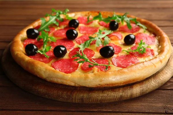 Tasty pizza with salami and olives on wooden background — Stock Photo, Image