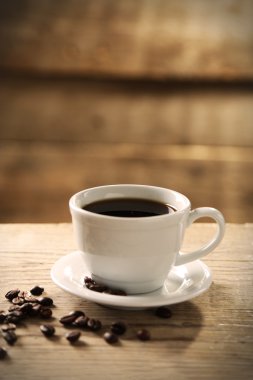 Fincan kahve ve kahve taneleri ahşap arka plan üzerinde