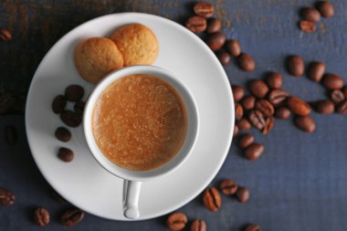 Ahşap masa arkasında bir fincan kahve.