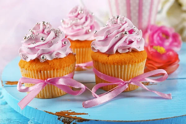 Smakelijke cupcakes op dienblad, op lichte achtergrond — Stockfoto