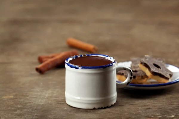 Cup of cacao with sweets on wooden table