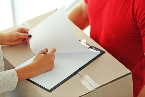 Woman signing delivery receipt — Stock Photo, Image