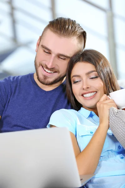 Pareja feliz sentada en sofá con café —  Fotos de Stock