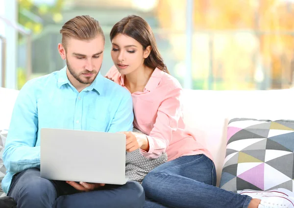 Pareja feliz y trabajando en un ordenador portátil —  Fotos de Stock