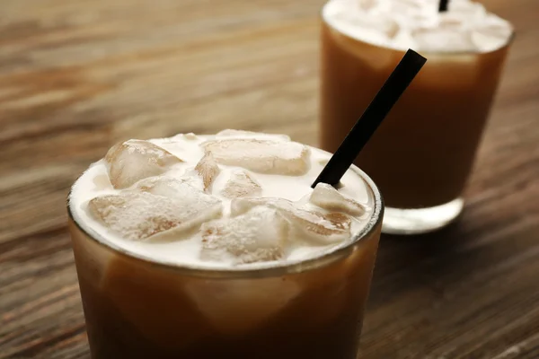 Due tazze di caffè ghiacciato con paglia su fondo di legno — Foto Stock