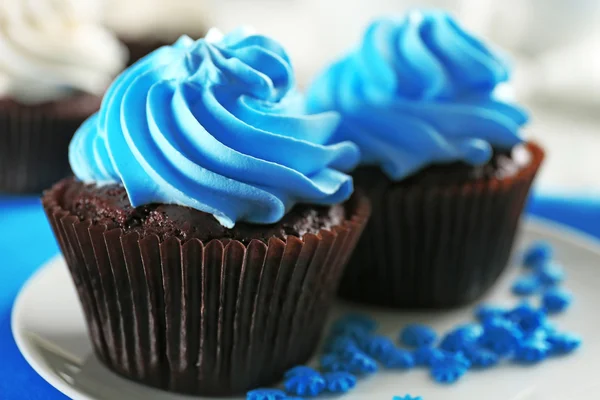 Deliciosos cupcakes de chocolate con crema azul en la mesa de madera decorada, de cerca —  Fotos de Stock
