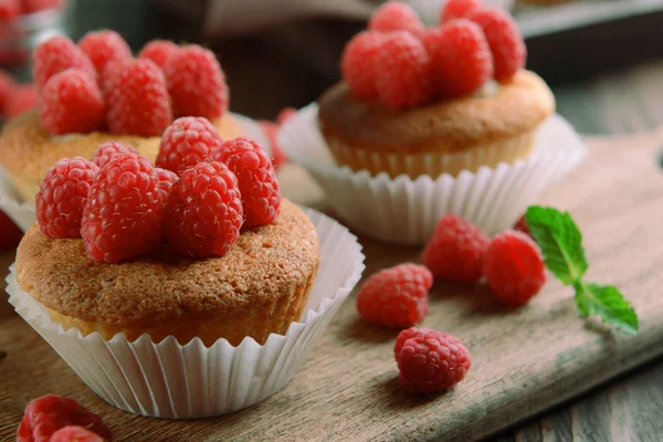 Heerlijke cupcakes met bessen en verse munt op houten tafel close-up — Stockfoto