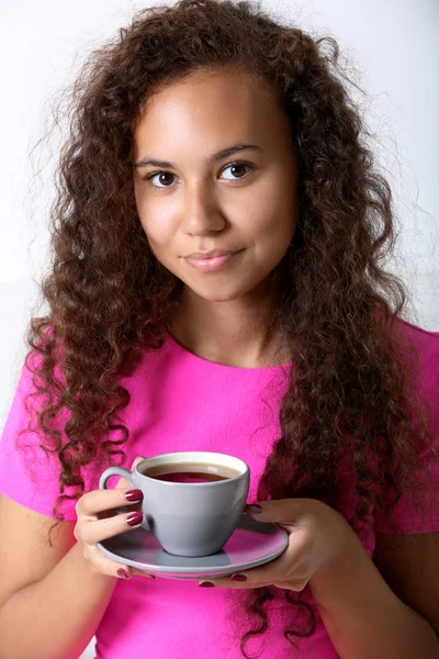 Νεαρή γυναίκα σε ροζ πουκάμισο πίνοντας καφέ — Φωτογραφία Αρχείου