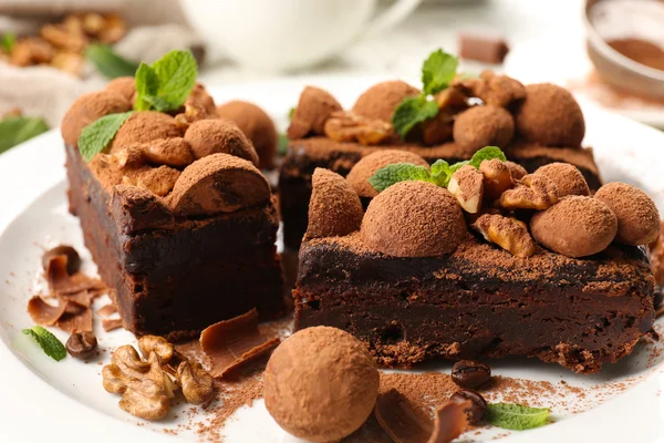 Ein Stück Schokoladenkuchen mit Walnuss und Minze auf dem Tisch, Nahaufnahme — Stockfoto