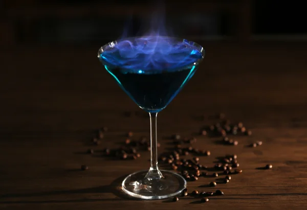 Cocktail bruciante e chicchi di caffè su un tavolo — Foto Stock
