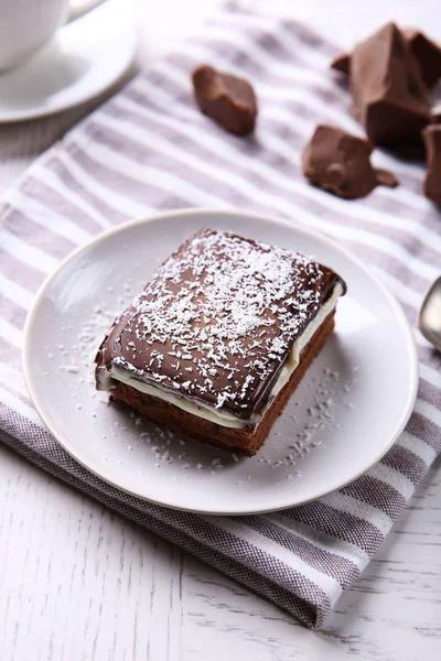 Heerlijke chocolade brownie op plaat op houten achtergrond — Stockfoto