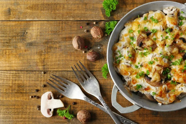 Смажені гриби, курячі та сирні решітки в сковороді, на дерев'яному фоні — стокове фото