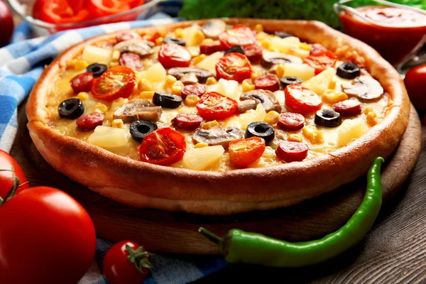 Pizza deliciosa com legumes e carne em guardanapo azul, close-up — Fotografia de Stock