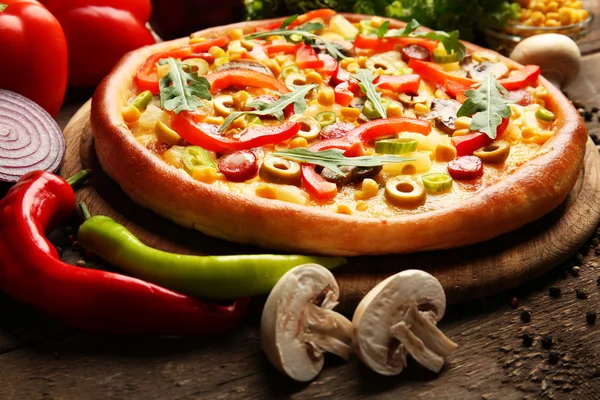 Delicious pizza with vegetables on wooden background — Stock Photo, Image