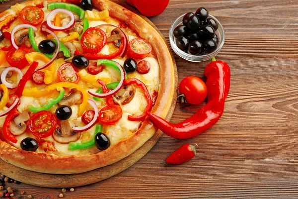 Leckere Pizza mit Gemüse, auf Holztisch — Stockfoto