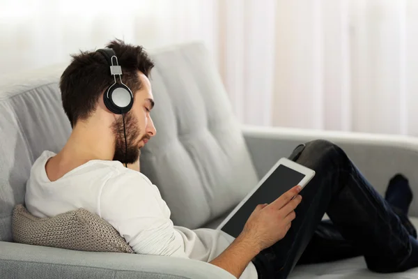 Jongeman luistert muziek met koptelefoon — Stockfoto