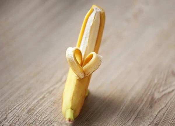 Coração feito de banana no fundo de madeira — Fotografia de Stock