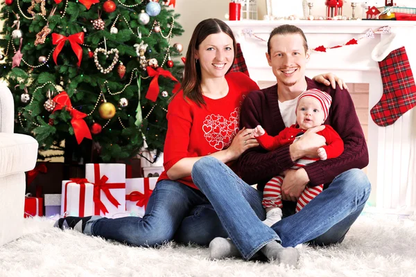 Glückliche Familie im geschmückten Weihnachtszimmer — Stockfoto