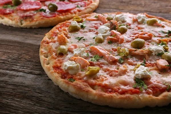 Ahşap arka plan üzerinde iki lezzetli lezzetli Pizza — Stok fotoğraf