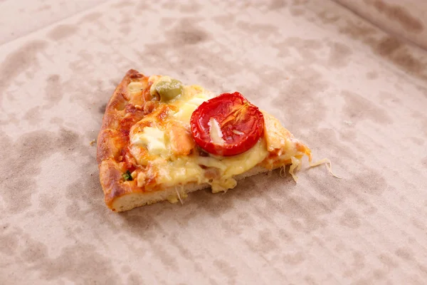 Кусок вкусной пиццы в картонке, крупным планом — стоковое фото