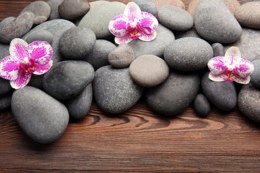 Spa taş ve ahşap arka plan üzerinde orkide