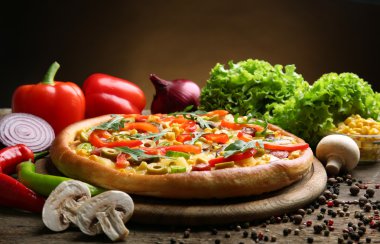 Kahverengi zemin üzerine sebzeli lezzetli pizza