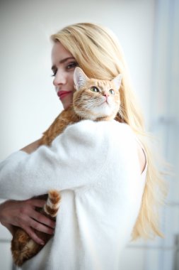 kadın kırmızı kedi elinde tutar.