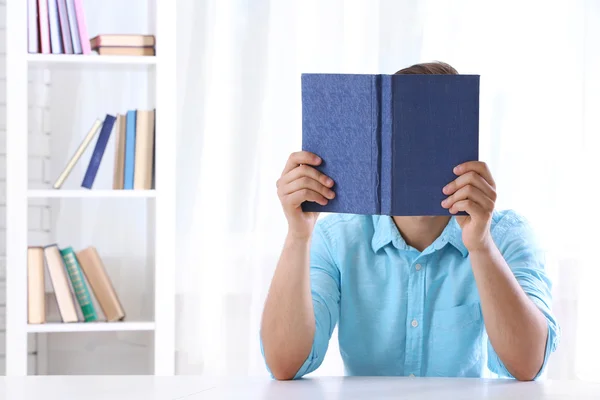 Joven leyendo libro en la mesa —  Fotos de Stock