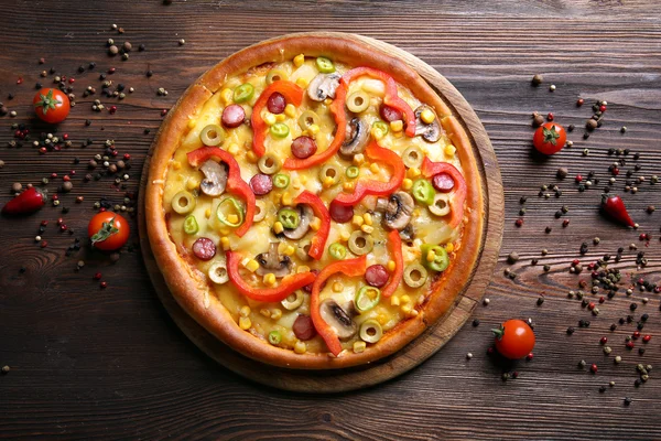 Heerlijke pizza met peper op houten tafel — Stockfoto