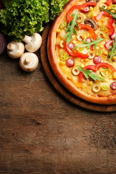 Вкусная пицца с салатом и шампанским на деревянном фоне — стоковое фото