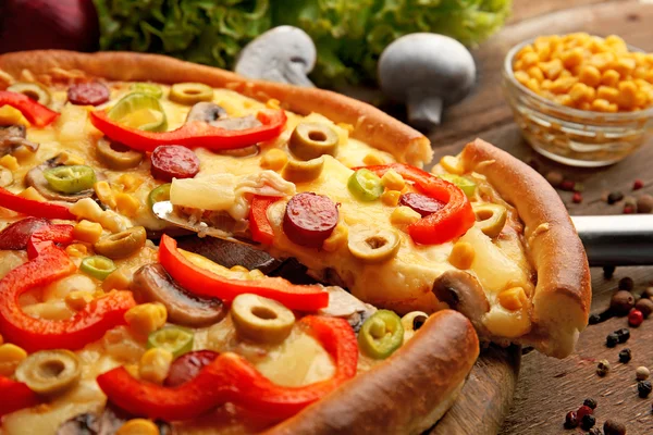 Deliciosa pizza con verduras y rebanada en la pala, primer plano —  Fotos de Stock