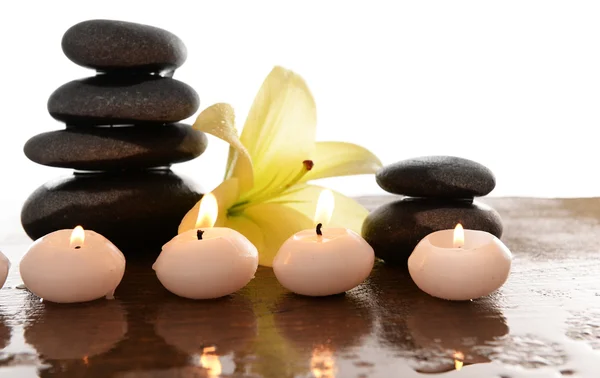 Spa stones with candles and lily, isolated on white — Stock Photo, Image