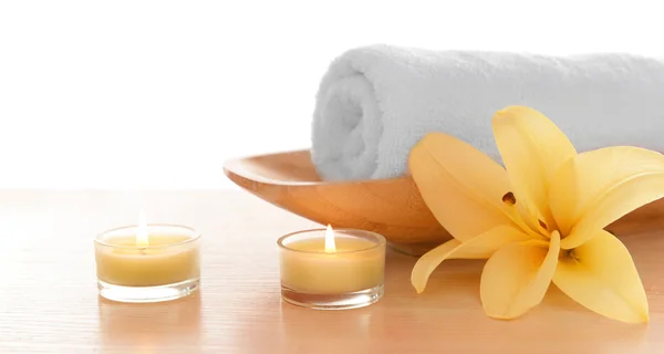 Spa towel with candles and lily, isolated on white — Stock Photo, Image