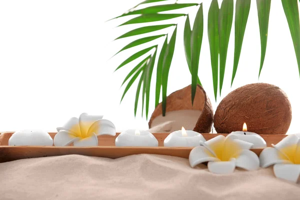 Kokosnuss mit Kerzen und Plumeria auf Sand, isoliert auf Weiß — Stockfoto