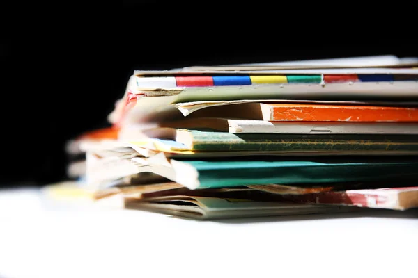 Pilha de livros na mesa contra a parede preta, close-up — Fotografia de Stock