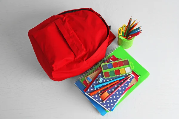 Mochila com material escolar na mesa de madeira — Fotografia de Stock