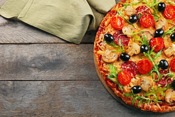 Heerlijke smakelijke pizza met ingrediënten op houten tafel — Stockfoto