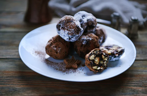 Chocolate balls on a plate on wooden background — Stock Photo, Image