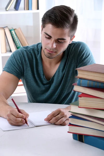 Young man reading book at table Stock Picture